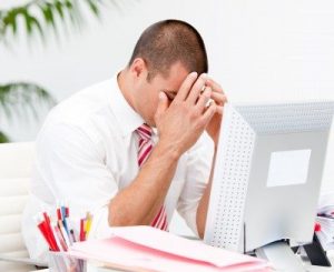 a man stressed in front of a computer