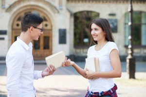 girl giving a book to a guy